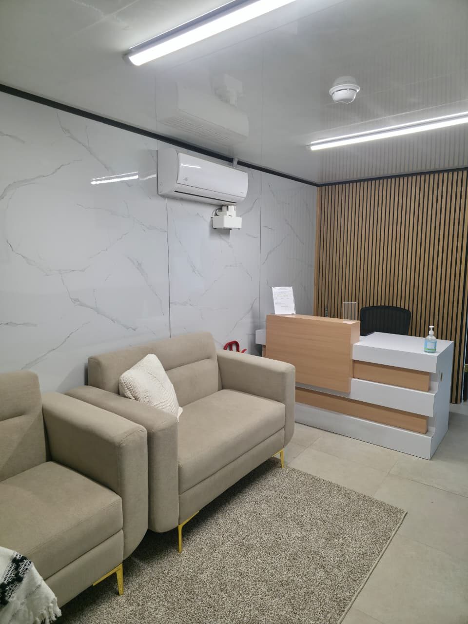 Sala de espera del consultorio con sillones y recepción